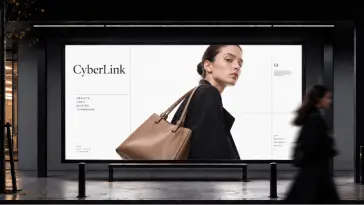 Una donna che passa davanti a un cartellone illuminato CyberLink che mostra una modella con una borsetta di pelle marrone chiaro
